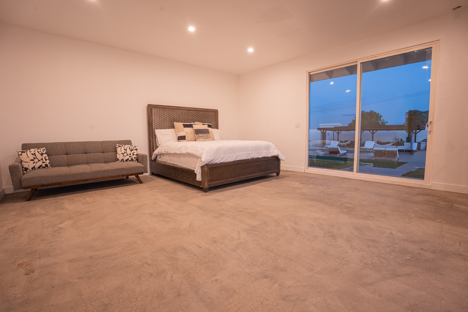 Golden-hour courtyard of a private desert estate perfect for spiritual retreat venue rental, pool reflecting warm evening light with boulders in the background
