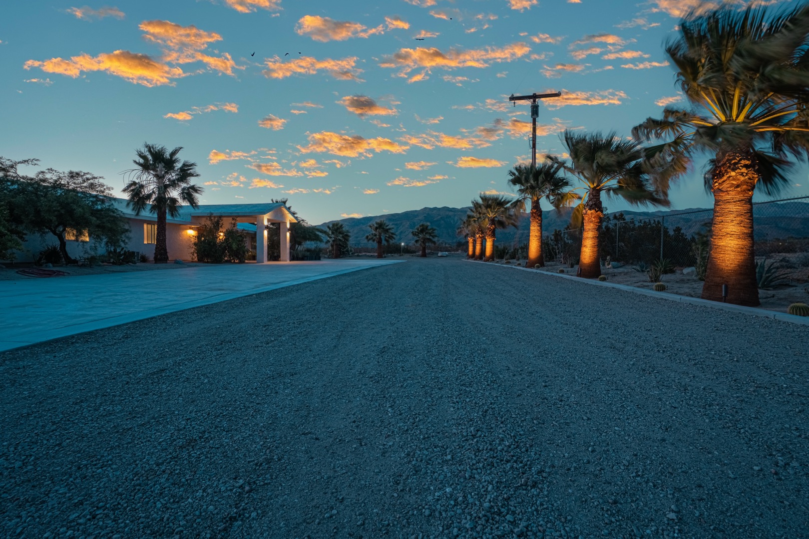 An outdoor communal dining table set for a culinary experience retreat space at golden hour on a private desert estate near Palm Springs