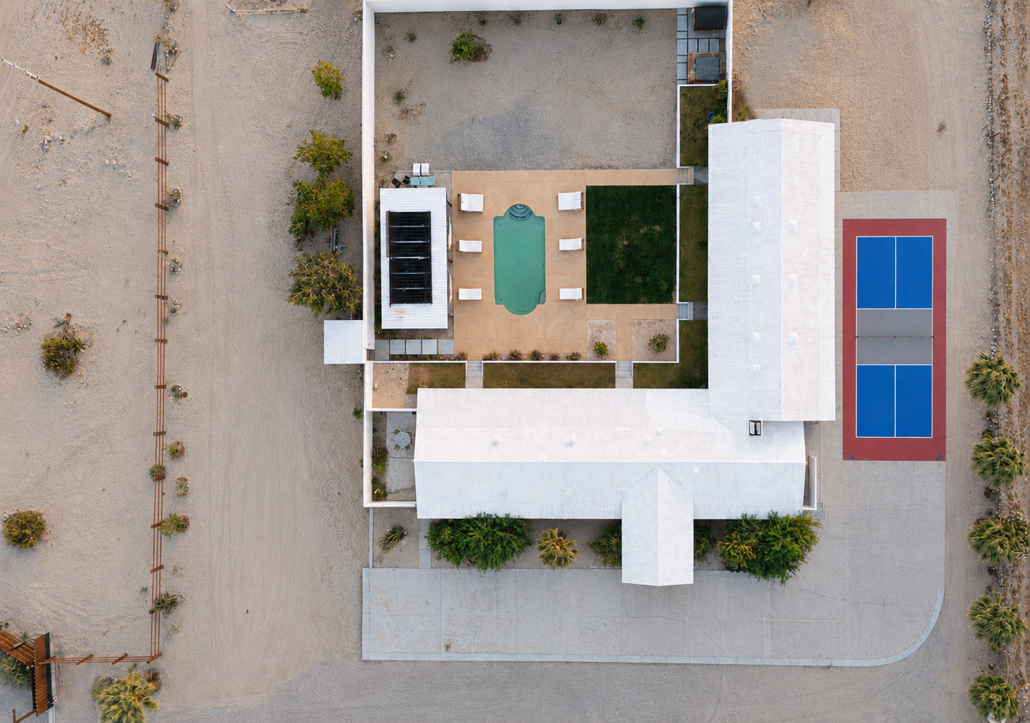 A private burnout prevention retreat space at golden hour on a five-acre Mojave desert estate near Palm Springs, with a glowing pool and open-air lounge area