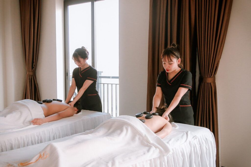 A serene scene of a woman receiving a hot stone massage in a spa, creating a calming atmosphere.
